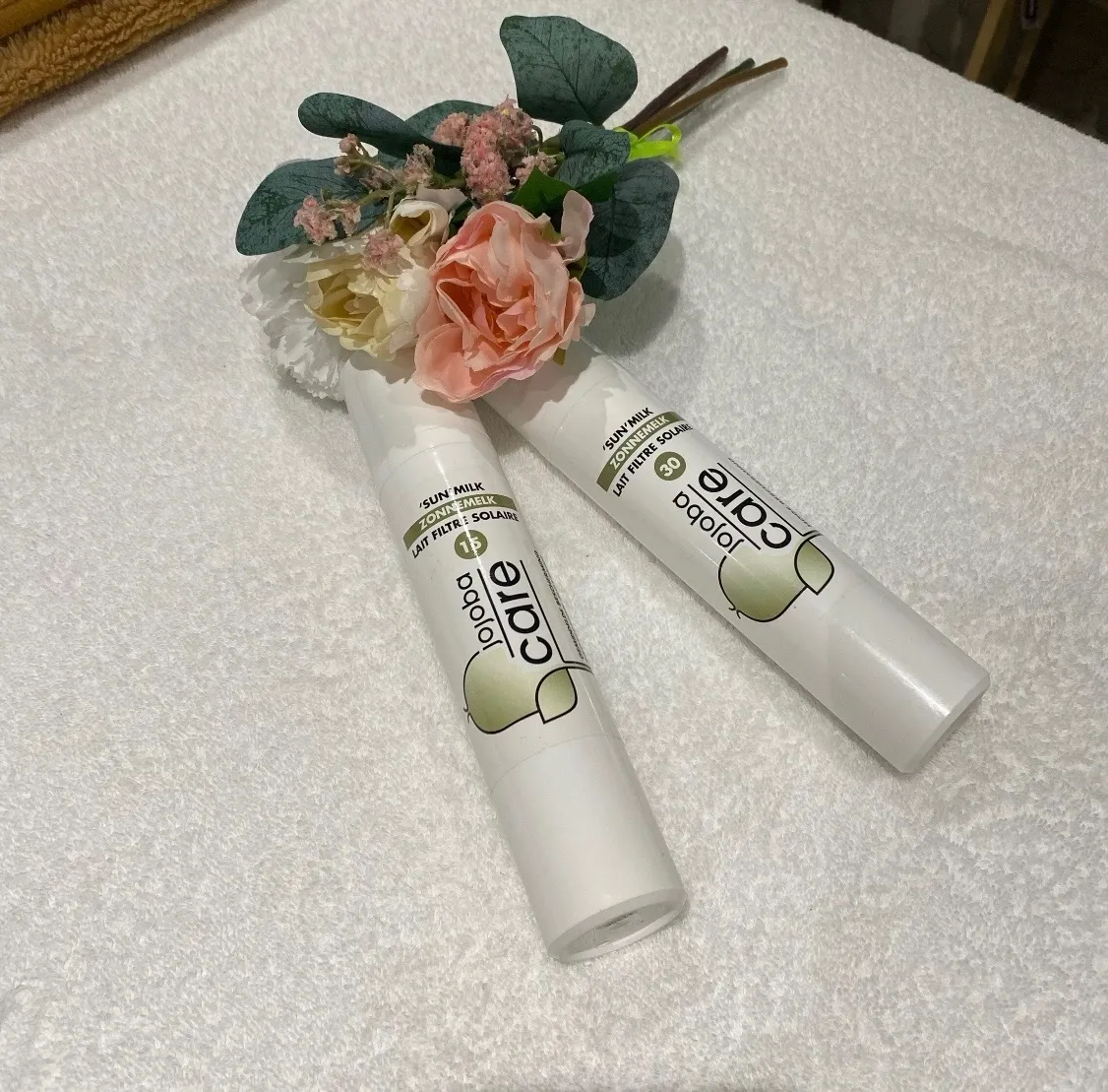 Soins Jojoba Care présentés avec des fleurs séchées